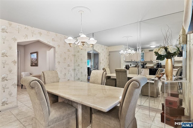 33 Irwin Pl, Bloomfield, NJ 07003 - dining room featuring a chandelier, wallpapered walls, arched walkways, light tile patterned floors, and baseboards