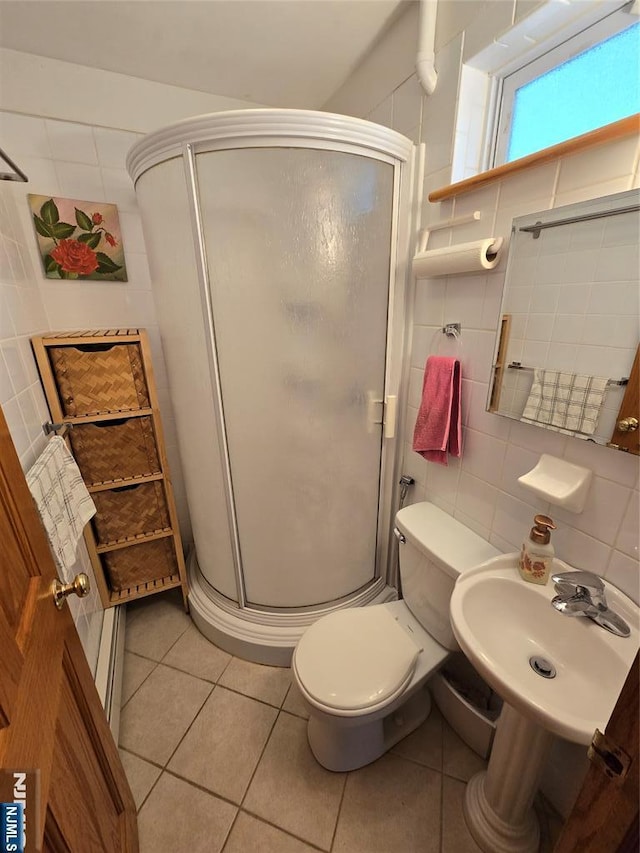 18 W Broad St, Bergenfield, NJ 07621 - bathroom with a stall shower, tile patterned floors, toilet, a sink, and tile walls