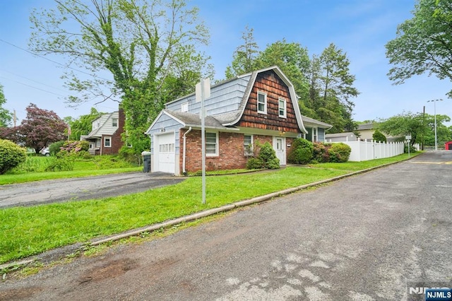 69 Bogert Pl, Bergenfield, NJ 07621 - view of front of property featuring asphalt driveway, a garage, brick siding, a gambrel roof, and a chimney