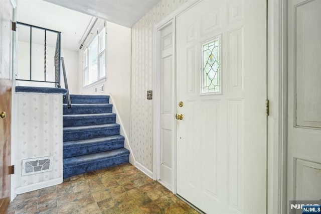 69 Bogert Pl, Bergenfield, NJ 07621 - entryway featuring baseboards, wallpapered walls, stairway, and stone finish floors