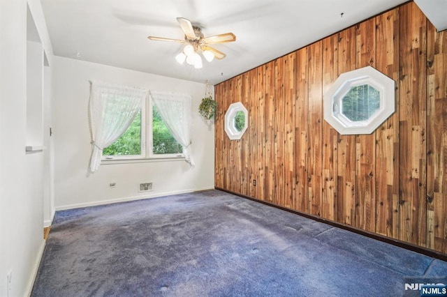 69 Bogert Pl, Bergenfield, NJ 07621 - unfurnished room with carpet, ceiling fan, wood walls, and baseboards