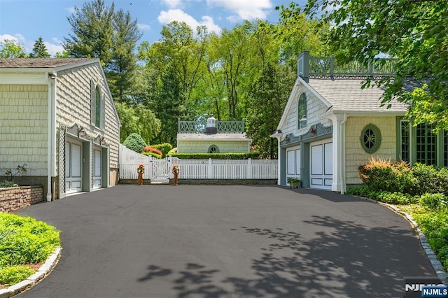 2 Olde Lantern Ct, Montvale, NJ 07645 - view of home's exterior featuring asphalt driveway, a chimney, an attached garage, and a shingled roof