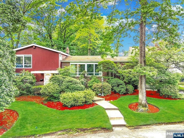 430 Jones Rd, Englewood, NJ 07631 - view of front of home featuring a front yard, a chimney, and brick siding