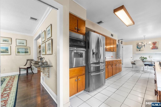 430 Jones Rd, Englewood, NJ 07631 - kitchen featuring appliances with stainless steel finishes, crown molding, a chandelier, brown cabinetry, and baseboards