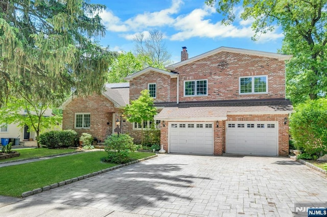 21 Sheridan Ave, West Orange, NJ 07052 - traditional-style home with decorative driveway, an attached garage, a front yard, a chimney, and brick siding