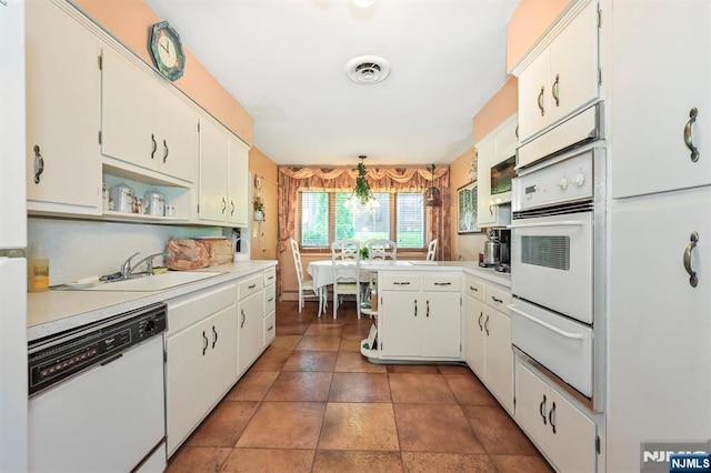 379 Mauro Rd, Englewood Cliffs, NJ 07632 - kitchen featuring white appliances, a warming drawer, a peninsula, light countertops, and white cabinets