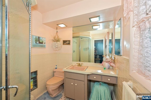379 Mauro Rd, Englewood Cliffs, NJ 07632 - bathroom with tile walls, vanity, a shower stall, and a wainscoted wall