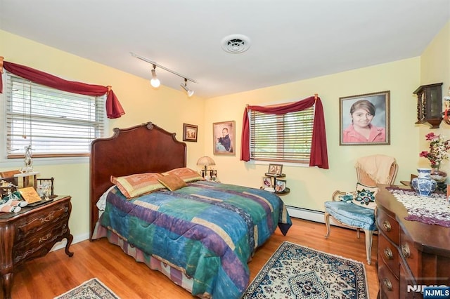 379 Mauro Rd, Englewood Cliffs, NJ 07632 - bedroom with track lighting, wood finished floors, and a baseboard radiator
