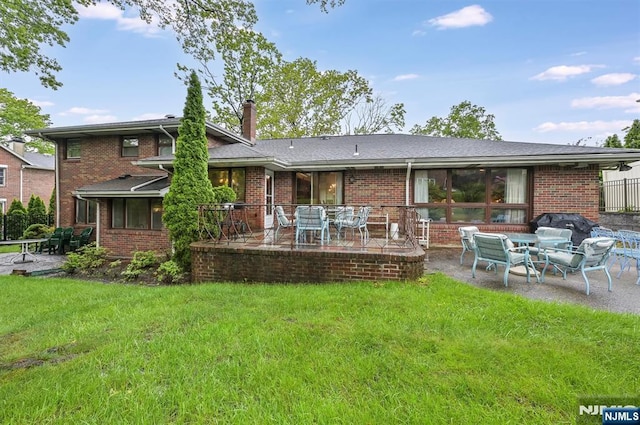 379 Mauro Rd, Englewood Cliffs, NJ 07632 - back of property with a patio, brick siding, a lawn, and a chimney