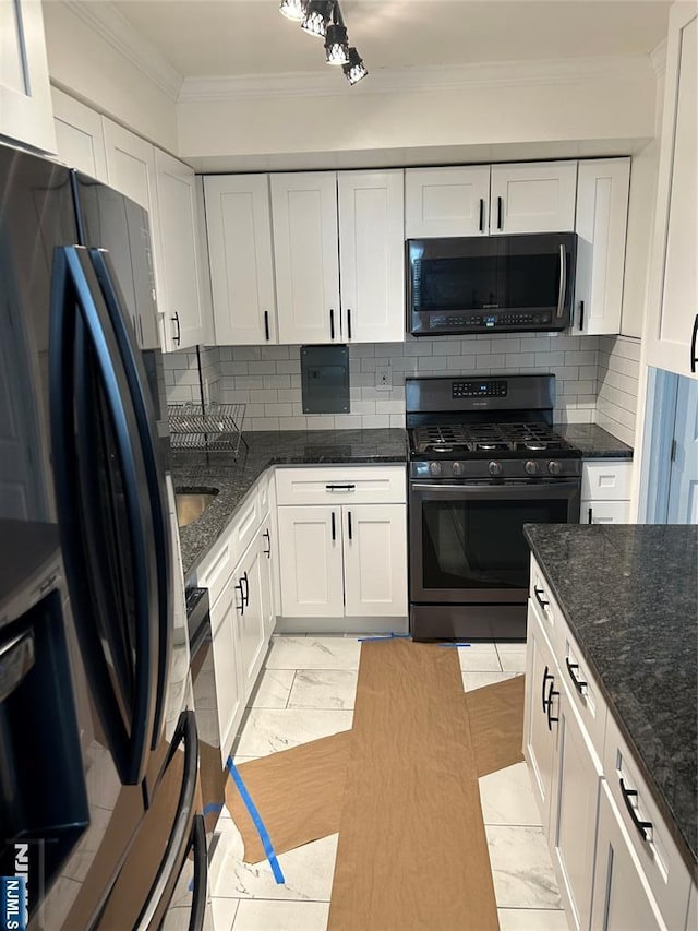 276 Prospect Unit 3H, East Orange, NJ 07017 - kitchen with gas stove, ornamental molding, black fridge, white cabinets, and tasteful backsplash