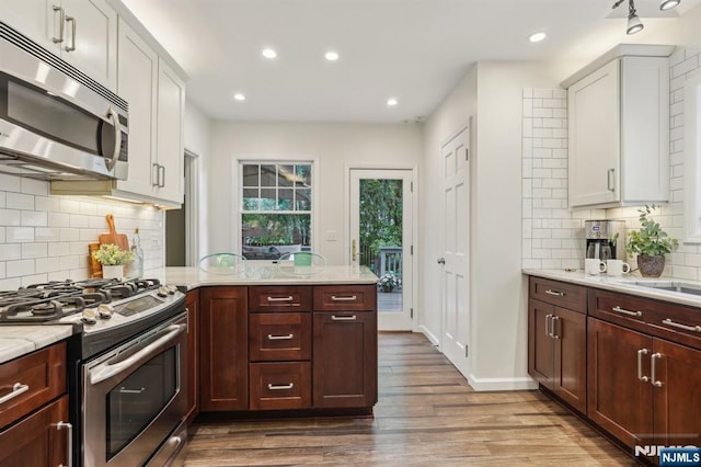5 Laurel Pl, Glen Ridge, NJ 07028 - kitchen featuring stainless steel appliances, dark wood-type flooring, a peninsula, tasteful backsplash, and recessed lighting