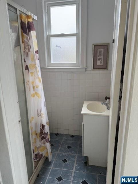 457 7th St, Newark, NJ 07107 - bathroom with tile walls, vanity, tile patterned floors, a shower stall, and wainscoting