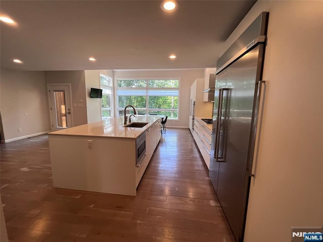 625 Roberge Dr, River Vale, NJ 07675 - kitchen featuring appliances with stainless steel finishes, a sink, white cabinets, dark wood finished floors, and an island with sink