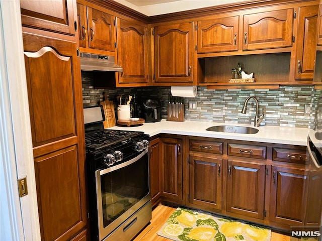 25 Osprey Unit G310, Hackettstown, NJ 07840 - kitchen with stainless steel range with gas stovetop, a sink, under cabinet range hood, light countertops, and backsplash