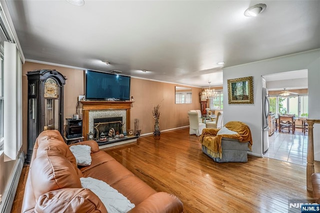 415 Briarwood Ln, Northvale, NJ 07647 - living area featuring a baseboard radiator, crown molding, a chandelier, baseboards, and light wood-style floors