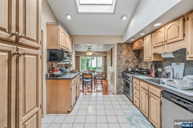 415 Briarwood Ln, Northvale, NJ 07647 - kitchen featuring stainless steel appliances, a skylight, a sink, light tile patterned floors, and ceiling fan