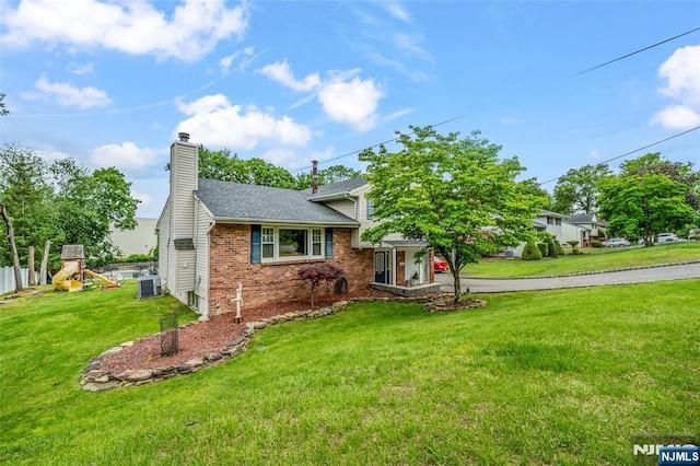 415 Briarwood Ln, Northvale, NJ 07647 - split level home with brick siding, central AC unit, a chimney, a front yard, and a playground
