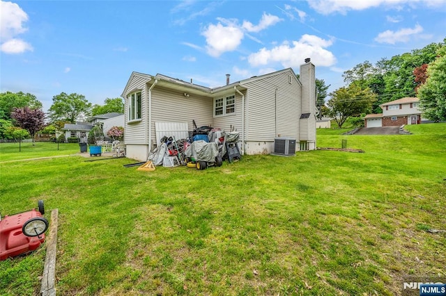 415 Briarwood Ln, Northvale, NJ 07647 - back of house featuring central AC unit, a chimney, and a lawn