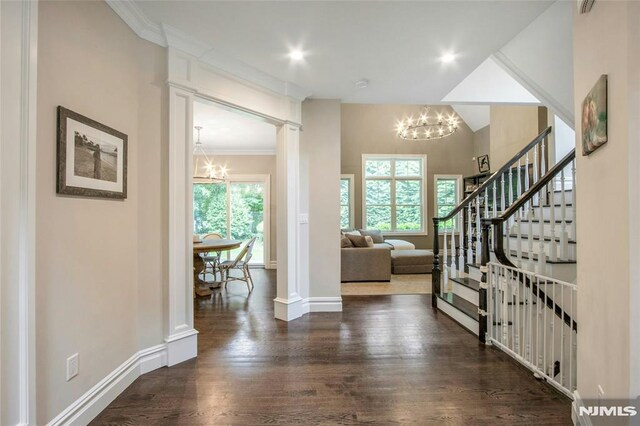 77 Ross Ave, Demarest, NJ 07627 - entrance foyer featuring a chandelier, dark wood-type flooring, baseboards, ornamental molding, and stairway