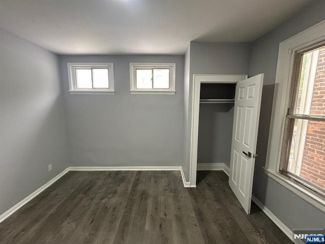 207 Tremont Ave, East Orange, NJ 07018 - unfurnished bedroom with baseboards, dark wood-style floors, and a closet