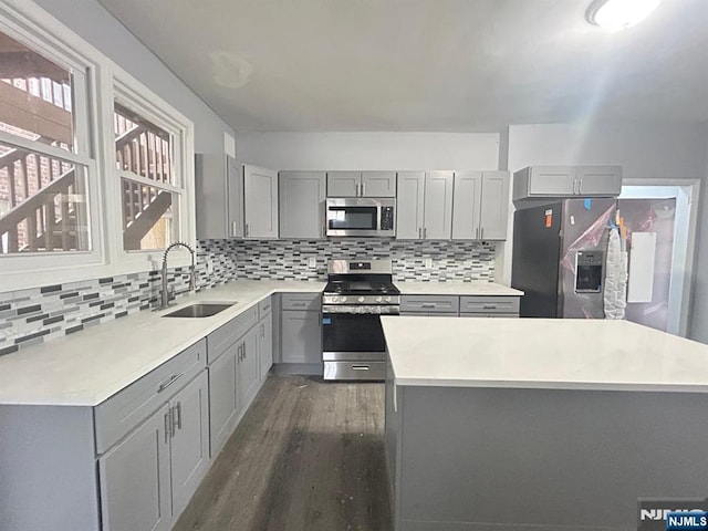 207 Tremont Ave, East Orange, NJ 07018 - kitchen featuring stainless steel appliances, gray cabinets, a sink, dark wood-type flooring, and backsplash