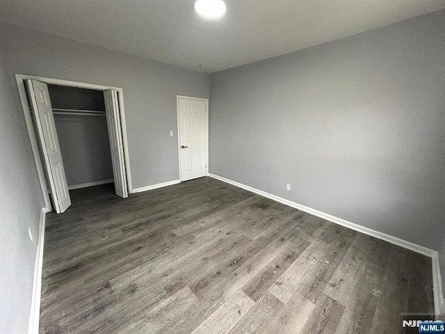 207 Tremont Ave, East Orange, NJ 07018 - unfurnished bedroom featuring dark wood-type flooring, baseboards, and a closet