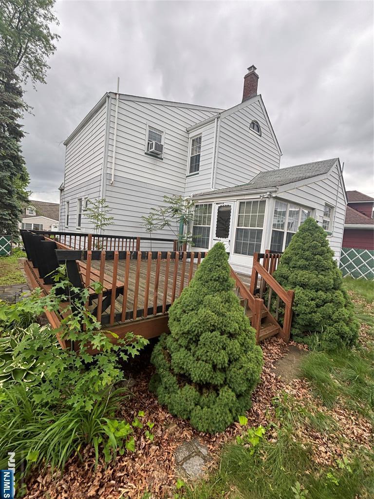 130 Riverview Ave, North Arlington, NJ 07031 - rear view of property with a chimney, a deck, and a sunroom