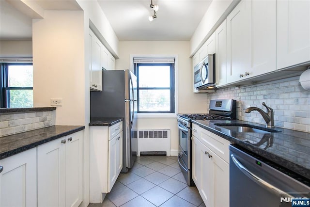 2333 Hudson Ter Unit A4, Fort Lee, NJ 07024 - kitchen featuring stainless steel appliances, a sink, decorative backsplash, white cabinetry, and radiator