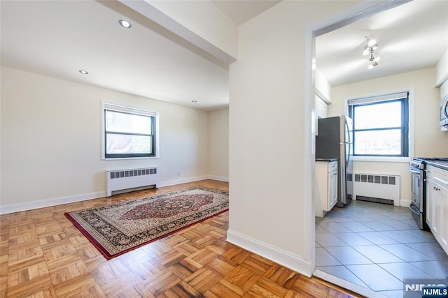 2333 Hudson Ter Unit A4, Fort Lee, NJ 07024 - kitchen with radiator heating unit, appliances with stainless steel finishes, white cabinetry, healthy amount of natural light, and recessed lighting