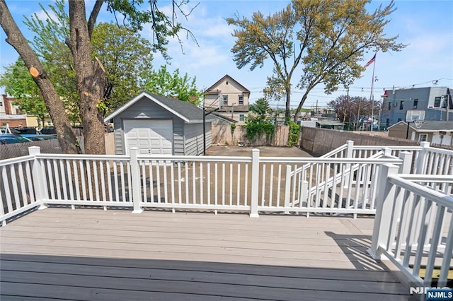 190 Washington Ave, Hackensack, NJ 07601 - wooden deck featuring a garage, a fenced backyard, and an outbuilding
