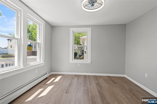190 Washington Ave, Hackensack, NJ 07601 - spare room with baseboard heating, plenty of natural light, wood finished floors, and baseboards