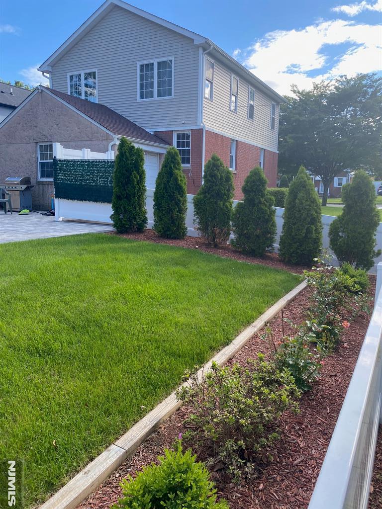 13-53 Sunnyside Dr, Fair Lawn, NJ 07410 - back of property with a yard and brick siding