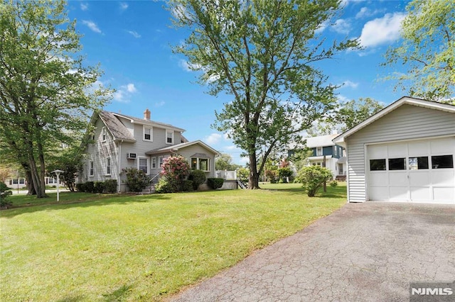 99 Comly Rd, Lincoln Park Borough, NJ 07035 - view of green lawn with asphalt driveway and a detached garage