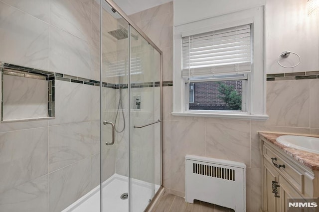 497 Oakdene Ave, Ridgefield, NJ 07657 - full bathroom featuring radiator heating unit, tile walls, a stall shower, and vanity