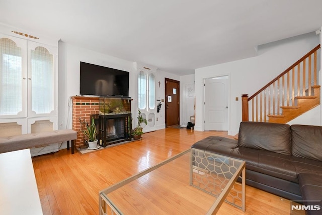 497 Oakdene Ave, Ridgefield, NJ 07657 - living room with wood finished floors, stairway, and a brick fireplace