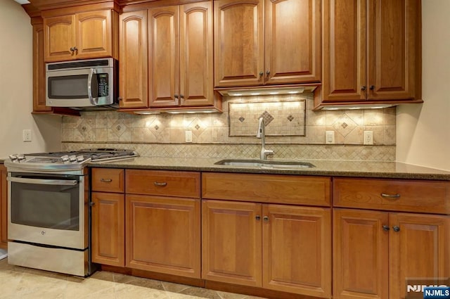 65 Cummings Ct, Mahwah, NJ 07430 - kitchen featuring stainless steel appliances, a sink, dark stone counters, backsplash, and brown cabinets
