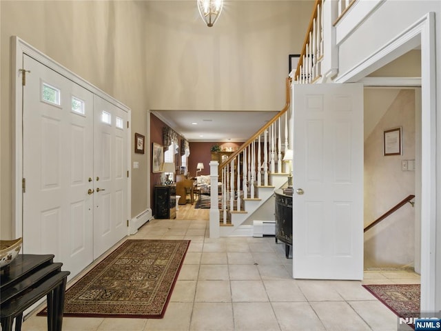 20 Tuxedo Ave, Park Ridge, NJ 07656 - foyer entrance featuring light tile patterned flooring, a baseboard radiator, a high ceiling, stairs, and baseboards