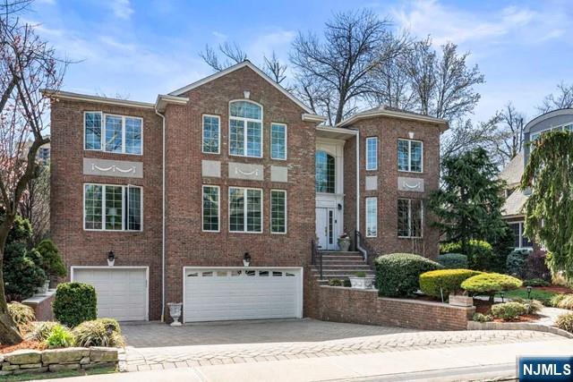 50 Claremont Rd, Fort Lee, NJ 07024 - traditional home with a garage, driveway, and brick siding