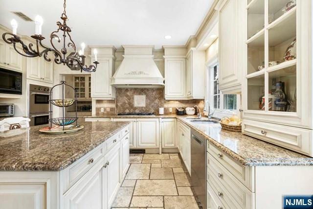 50 Claremont Rd, Fort Lee, NJ 07024 - kitchen with a sink, custom exhaust hood, appliances with stainless steel finishes, stone tile flooring, and a chandelier