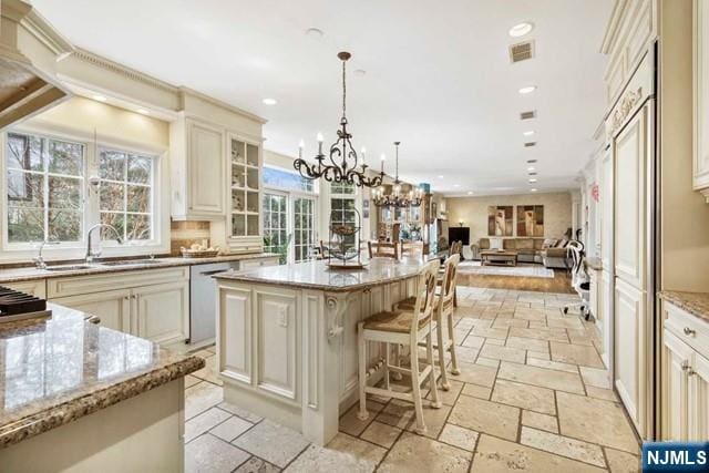 50 Claremont Rd, Fort Lee, NJ 07024 - kitchen featuring cream cabinetry, stone tile flooring, a sink, open floor plan, and light stone countertops