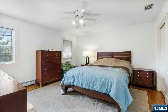 50 Claremont Rd, Fort Lee, NJ 07024 - bedroom with wood finished floors, a baseboard radiator, and ceiling fan