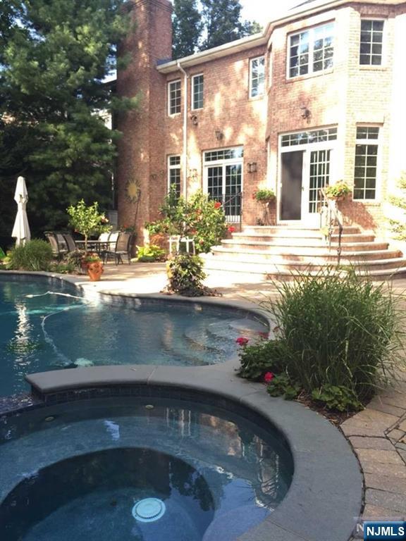 50 Claremont Rd, Fort Lee, NJ 07024 - back of property featuring an in-ground hot tub, an outdoor pool, a chimney, and a patio area
