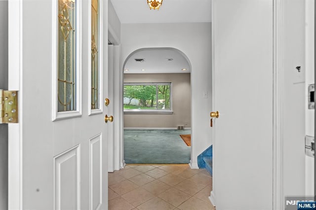 15 Strawberry Hill Rd, Hillsdale, NJ 07642 - foyer featuring light colored carpet, arched walkways, light tile patterned flooring, and baseboards