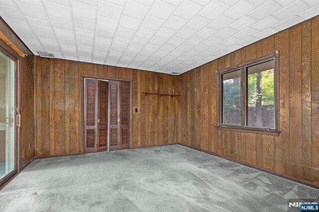 15 Strawberry Hill Rd, Hillsdale, NJ 07642 - carpeted empty room with wood walls and baseboards