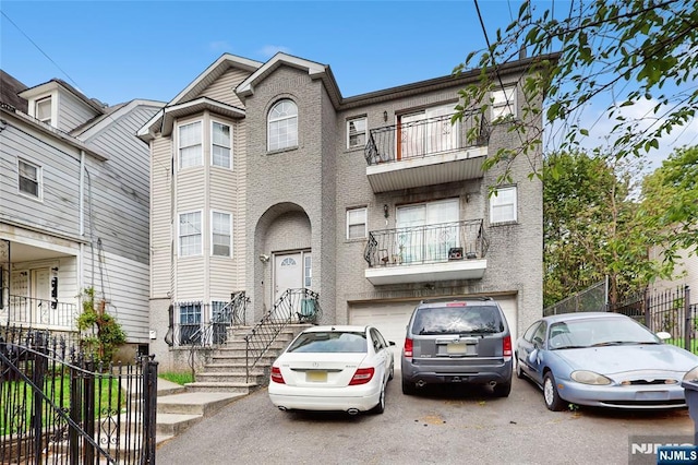 129-131 Seymour Ave, Newark, NJ 07108 - view of property featuring a garage, driveway, and a balcony