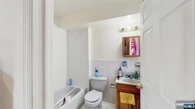 129-131 Seymour Ave, Newark, NJ 07108 - full bathroom featuring vanity, toilet, tile walls, tile patterned floors, and a wainscoted wall