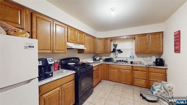129-131 Seymour Ave, Newark, NJ 07108 - kitchen with freestanding refrigerator, gas stove, under cabinet range hood, light tile patterned floors, and brown cabinetry