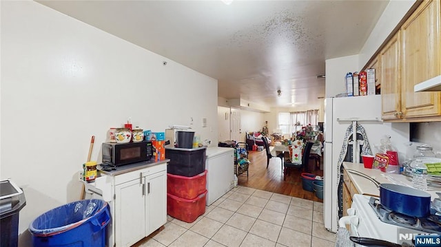 129-131 Seymour Ave, Newark, NJ 07108 - kitchen featuring black microwave, light tile patterned floors, white gas range oven, and light countertops