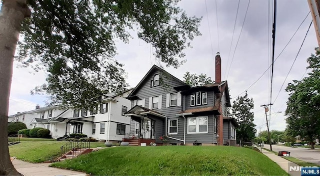 336-338E 41st St, Paterson, NJ 07504 - view of front of home featuring a chimney and a front yard
