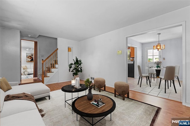 9 Rutan Pl, Bloomfield, NJ 07003 - living room featuring light wood-style floors, stairway, a chandelier, and baseboards